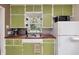 Charming kitchen features green cabinetry, butcher block countertops, and a window over the sink at 1727 S Irvington Ave, Indianapolis, IN 46203