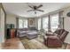 Bright living room with a large window, ceiling fan, hardwood floors, and a recliner at 1727 S Irvington Ave, Indianapolis, IN 46203