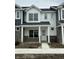 Charming townhome with white siding, stone accents, covered porch, and sidewalk at 19571 Grassy Branch Dr, Westfield, IN 46074