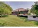 Expansive backyard featuring a patio with awning, lush green lawn, and mature trees at 214 W Stoney Trl, Greenfield, IN 46140
