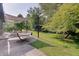 Spacious backyard featuring a covered patio, hammock, and lush green lawn with mature trees at 214 W Stoney Trl, Greenfield, IN 46140