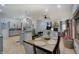 Open dining area with wood floors, a view into the living room and kitchen with gray cabinets at 214 W Stoney Trl, Greenfield, IN 46140