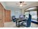 Well-lit home office features a ceiling fan, neutral walls, and comfortable furnishings at 214 W Stoney Trl, Greenfield, IN 46140