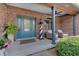 Cozy porch area with a light house, wicker chairs, and a turquoise door at 214 W Stoney Trl, Greenfield, IN 46140