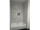 A bathroom showing a bath tub and gray decorative wall tiles at 2148 N Pennsylvania St, Indianapolis, IN 46202
