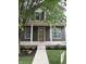 Charming two-story home with a covered front porch, complemented by dark green siding and beautifully landscaped flowerbeds at 2148 N Pennsylvania St, Indianapolis, IN 46202