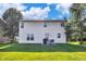 Rear exterior of a two-story house with a door leading to the backyard, and a patio with furniture and a grill at 2211 Willowview Dr, Indianapolis, IN 46239