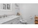 Charming powder room featuring white marble countertops, a toilet, and a decorative mirror at 2211 Willowview Dr, Indianapolis, IN 46239