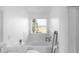 Bathroom with soaking tub, white tile, and a large window providing natural light and views at 2211 Willowview Dr, Indianapolis, IN 46239