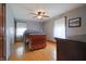 Neutral bedroom with wood floors, ceiling fan, a dresser, and window with natural light at 2309 Maple St, Columbus, IN 47201