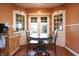 Cozy dining nook featuring hardwood floors, a view of the front yard, and built-in corner cabinets at 2309 Maple St, Columbus, IN 47201