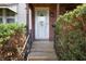 Inviting front entrance with a decorative storm door, brick accents, and manicured shrubs along the walkway at 2309 Maple St, Columbus, IN 47201