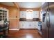 Well-lit kitchen features white cabinets, stainless steel appliances, tile backsplash, and hardwood floors at 2309 Maple St, Columbus, IN 47201