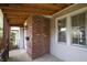 Relaxing porch area featuring brick accents, wood ceiling, and views of the front yard and landscape at 2309 Maple St, Columbus, IN 47201