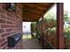 Cozy porch with brick accents, wood ceiling and trim, mail box, and lush shrubs in the front yard at 2309 Maple St, Columbus, IN 47201