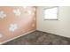 Cozy bedroom with carpet, peach accent wall and white floral design at 258 N Green Springs Rd, Indianapolis, IN 46214