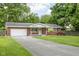 Charming brick home featuring a covered front porch, manicured lawn, and colorful shrubbery at 258 N Green Springs Rd, Indianapolis, IN 46214