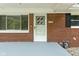 Close up of the brick-lined front porch and front door featuring modern house number at 258 N Green Springs Rd, Indianapolis, IN 46214