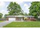 Charming red brick ranch home with a well-manicured lawn and attached two-car garage at 258 N Green Springs Rd, Indianapolis, IN 46214