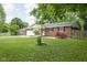 Charming brick home featuring a covered front porch, manicured lawn, and colorful shrubbery at 258 N Green Springs Rd, Indianapolis, IN 46214