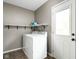 Functional laundry room with full size washer and dryer, shelves, and outside door at 258 N Green Springs Rd, Indianapolis, IN 46214
