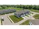 Aerial view of townhomes with attached garages, green spaces, and a park in the background at 2892 Maricopa Blvd, Whitestown, IN 46075