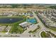An aerial view of a community featuring houses, a pond, a pool, a tennis court, and lush green spaces at 2892 Maricopa Blvd, Whitestown, IN 46075
