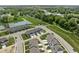 Wide aerial view of a neighborhood featuring townhomes, green spaces, a pond, and mature trees at 2892 Maricopa Blvd, Whitestown, IN 46075