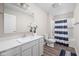 Inviting bathroom with a white vanity, sink, toilet, and a bathtub with a striped curtain at 2892 Maricopa Blvd, Whitestown, IN 46075