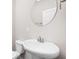 Modern bathroom featuring a white pedestal sink, round mirror, and toilet at 2892 Maricopa Blvd, Whitestown, IN 46075