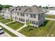 Beautiful townhome featuring a well-manicured lawn, classic brick facade, and modern black shutters at 2892 Maricopa Blvd, Whitestown, IN 46075