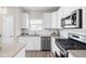 Modern kitchen boasts white cabinets, stainless appliances, and light stone countertops at 2892 Maricopa Blvd, Whitestown, IN 46075