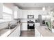 Well-lit kitchen featuring white cabinets, stainless steel appliances, and neutral countertops at 2892 Maricopa Blvd, Whitestown, IN 46075