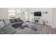Comfortable living room with gray sectional sofa, wood flooring, and bright natural light at 2892 Maricopa Blvd, Whitestown, IN 46075