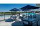 The pool area features tables with umbrellas and chairs near a pool and lake at 2892 Maricopa Blvd, Whitestown, IN 46075