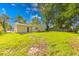 The backyard features green grass and a mature shade tree for outside enjoyment at 3817 Strathmore Dr, Indianapolis, IN 46235