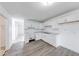 Contemporary kitchen with white cabinets and laminate flooring adjacent to a tiled space at 3817 Strathmore Dr, Indianapolis, IN 46235