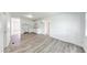 Open kitchen area with white cabinets and wood-look laminate flooring extending to the living space at 3817 Strathmore Dr, Indianapolis, IN 46235