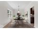 Formal dining room with modern table setting, artwork, hardwood floors, and natural light at 3823 Vanguard Cir, Carmel, IN 46032