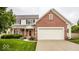 Two-story home with brick and siding, featuring an attached garage and a well-maintained lawn with shrubs at 3823 Vanguard Cir, Carmel, IN 46032