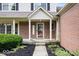 Charming front porch with brick accents, decorative door, and manicured landscaping with black mulch at 3823 Vanguard Cir, Carmel, IN 46032