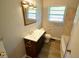This clean bathroom includes a large mirror, updated vanity, and tile surround in the bath at 3922 N Irvington Ave, Indianapolis, IN 46226