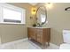 Stylish bathroom featuring a modern vanity, oval mirror, and elegant lighting fixtures at 4002 Guilford Ave, Indianapolis, IN 46205