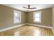 Bright bedroom with hardwood floors, ceiling fan, and natural light from two windows at 4002 Guilford Ave, Indianapolis, IN 46205