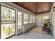 Inviting front porch with a seating area, wood ceilings, large windows, and a secure front door at 4002 Guilford Ave, Indianapolis, IN 46205