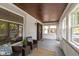 Inviting front porch with a seating area, wood ceilings, large windows, and a secure front door at 4002 Guilford Ave, Indianapolis, IN 46205