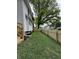 Side yard features a new wooden fence, grass, and landscaping against a white house with a large tree at 4002 Guilford Ave, Indianapolis, IN 46205