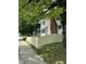 Side yard features a tall wooden fence and a view of the house from the sidewalk and street at 4002 Guilford Ave, Indianapolis, IN 46205