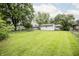 View of the backyard featuring a large lawn, privacy fence, and mature trees at 4020 Alden Ave, Indianapolis, IN 46221