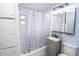 Bathroom with granite vanity sink, framed mirror with lighting, and a checkered pattern shower curtain at 4020 Alden Ave, Indianapolis, IN 46221